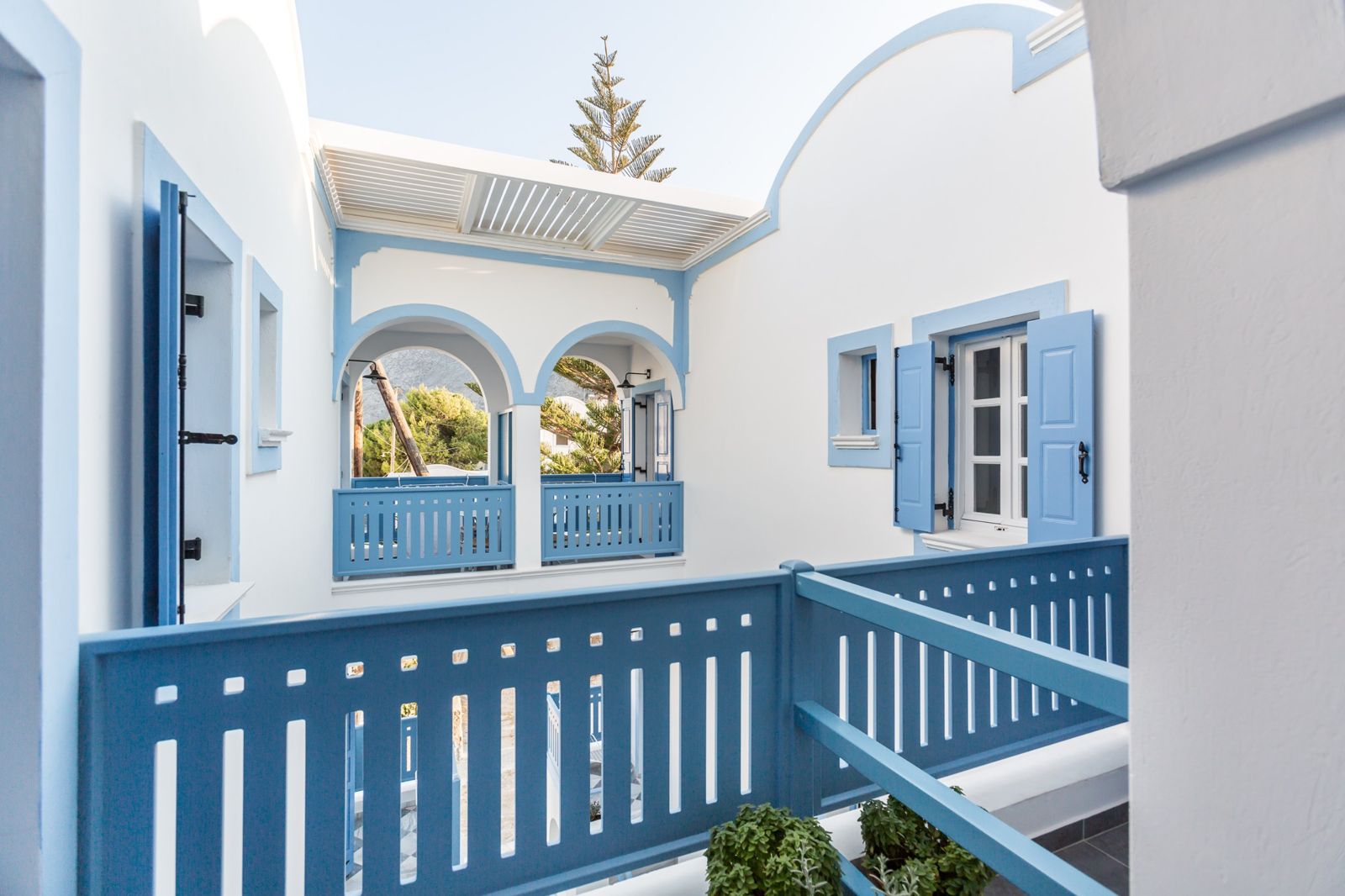 Twin blue arches and pergola on the upper floor of Fanouris Condo