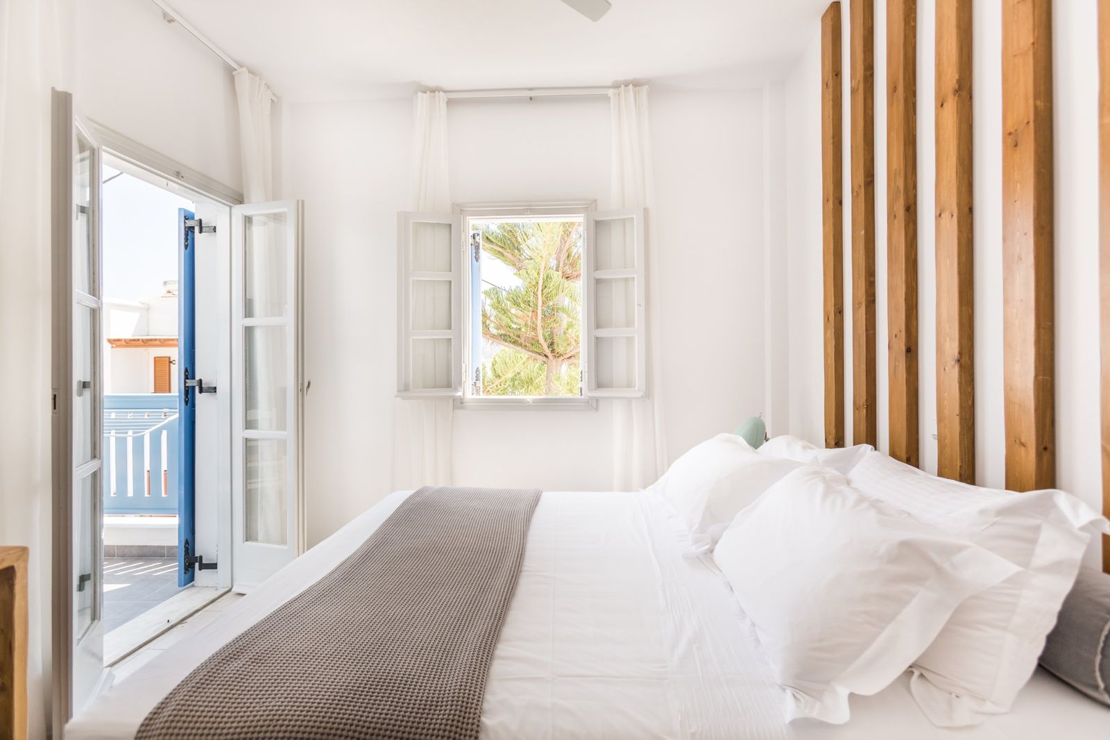 Bedroom of the Traditional Apartment with white linen and balcony doors